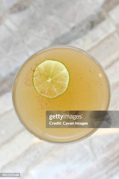 overhead view of cocktail with lime slice in coupe glass on table - cocktail glass salt stock pictures, royalty-free photos & images