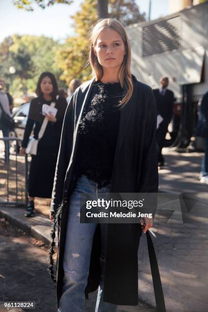 Model Anna Ewers a black jacket, black top, and blue jeans after the Miu Miu show at Palais d'Iena on October 05, 2016 in Paris, France.