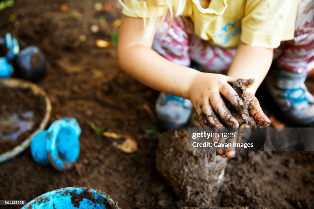 High angle view of girl playing with mud