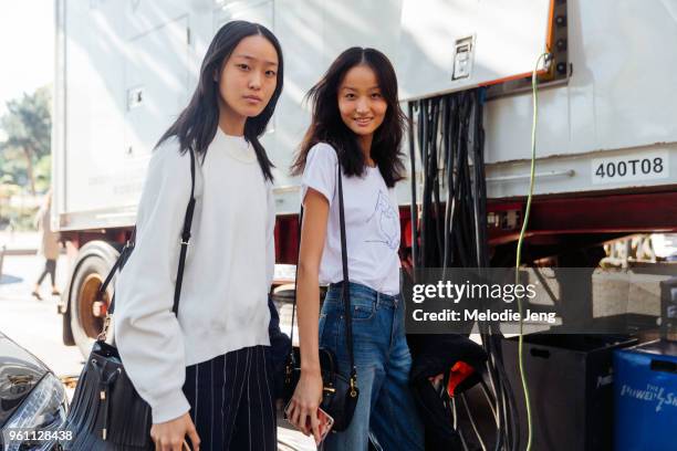 Chinese model Yue Han and Liu Xiu after the Miu Miu show at Palais d'Iena on October 05, 2016 in Paris, France. Both models wear white tops.