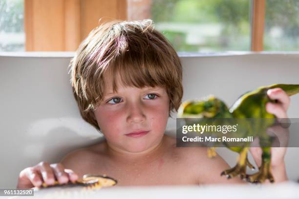 4 year old boy in bathtub playing with toy dinosaurs - lamy new mexico stock pictures, royalty-free photos & images