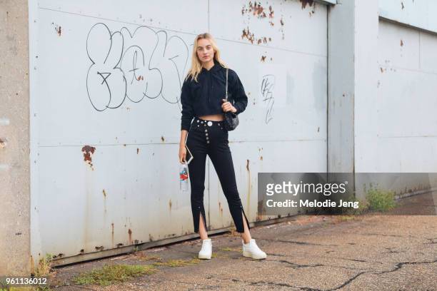 Model Maartje Verhoef wears a cropped black hoodie, black Versace pants, and white Celine sneakers during New York Fashion Week Spring/Summer 2018 on...