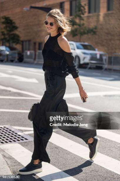Model Sanne Vloet wears all black - a sleeveless net top, black pants, and Celine shoes during New York Fashion Week Spring/Summer 2018 on September...