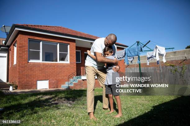 indigenous australian aboriginal father and son in backyard of australian suburban house - austraal aziatische volksstammen stockfoto's en -beelden