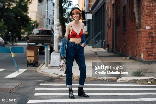 Model Ina Maribo Jensen wears a black beret, red bra top, denim jacket off her shoulders, blue jeans, and black boots during New York Fashion Week...