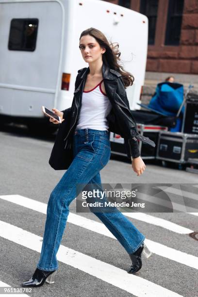 Model Margaux Lenot wears a black leather jacket, white tanktop, blue jeans, and black heels with a lucite heel during New York Fashion Week...
