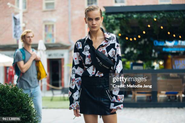 Model Nina Marker wears a Coup de Coeur bumbag, shirt with playing cards, and black leather miniskirt with a zipper and belt during New York Fashion...