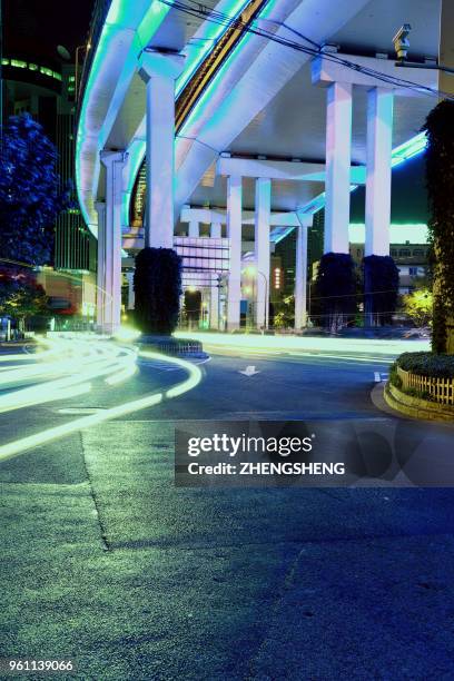 city road at landmark curve elevated highway overpass of gorgeous night scene of car light trails - road light trail stock pictures, royalty-free photos & images