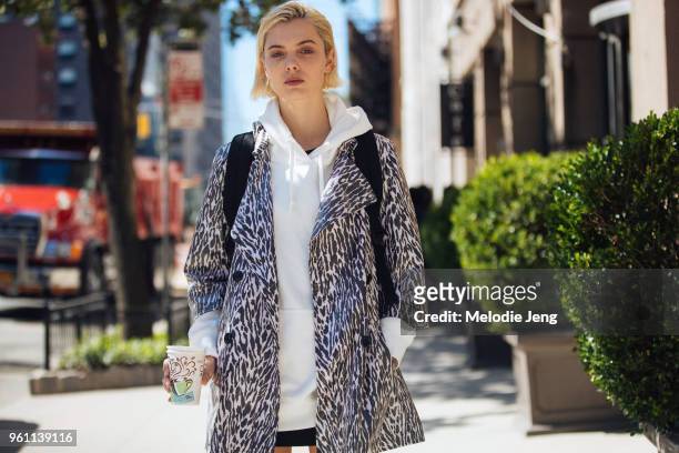 Model Emma Boyd holds a coffee cup and wears a zebra print jacket and white hoodie during New York Fashion Week Spring/Summer 2018 on September 9,...