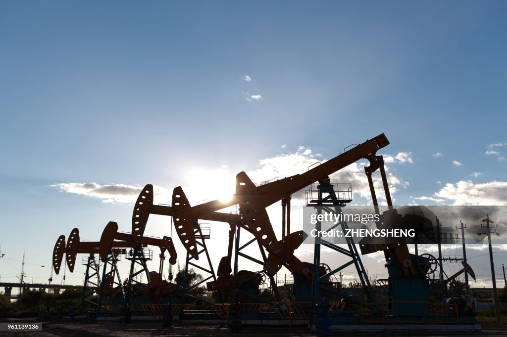 Golden yellow oil rig energy industry machine oil crude In the sunset backlighting