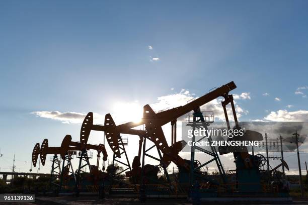 golden yellow oil rig energy industry machine oil crude in the sunset backlighting - zhengsheng fotografías e imágenes de stock