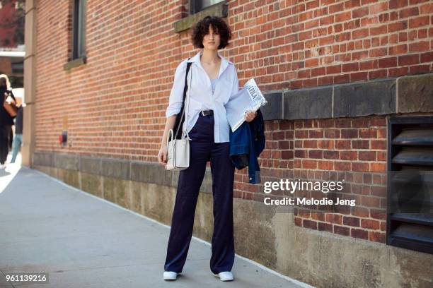 Model Leila Zandonai wears a white shirt, white Celine bag, blue pants, and white shoes during New York Fashion Week Spring/Summer 2018 on September...