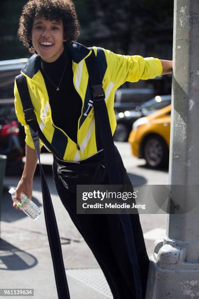 Model Dilone swings from a pole and wears a neon yellow Fenty Puma outfit during New York Fashion Week Spring/Summer 2018 on September 10, 2017 in...