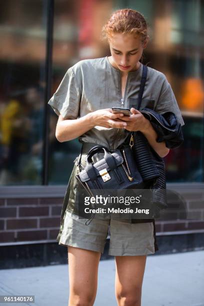 Model Lois Schalkwijk checks her phone and wears a green one piece and carries a Phillip Lim bag after the 3.1 Phillip Lim bag during New York...