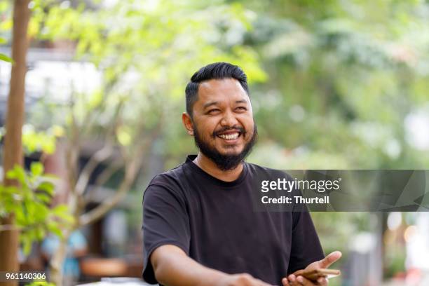 happy young asian man on bicycle - malaysia culture stock pictures, royalty-free photos & images
