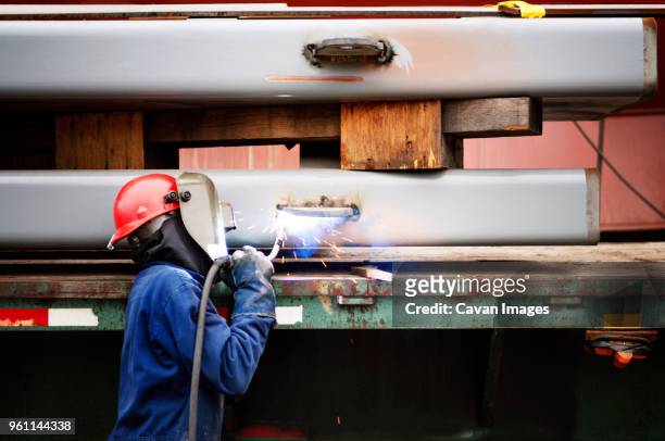 side view of worker welding ship at industry - last shipment of hostess twinkies arrives in chicago area stores stockfoto's en -beelden