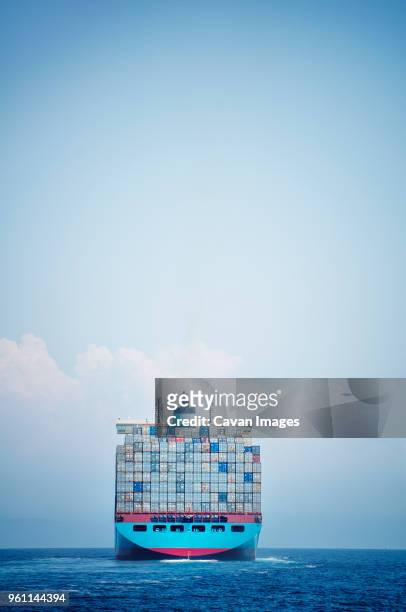 container ship sailing on sea against sky - container stock pictures, royalty-free photos & images