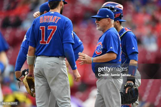 Manager Joe Maddon of the Chicago Cubs meets with his team on the mound during a game against the Cincinnati Reds at Great American Ball Park on May...