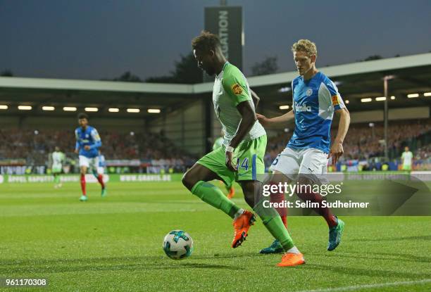 Divock Origi of VfL Wolfsburg fights for the ball with Johannes van den Bergh of Holstein Kiel during the Bundesliga Playoff Leg 2 between Holstein...