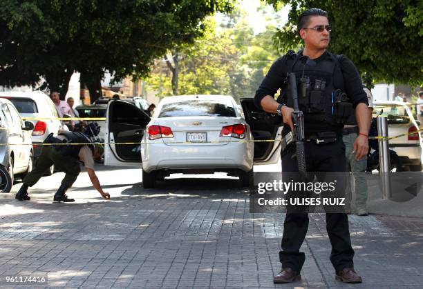 Ministerial police officers are seen at the site of an attack against Secretary of Labour and ex-prosecutor of Jalisco Luis Carlos Najera in which...