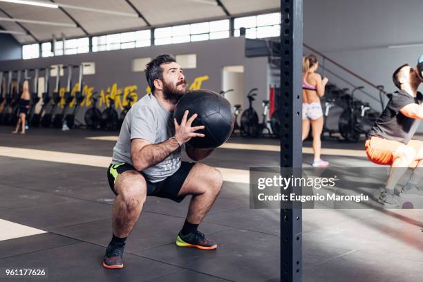 man in gym using medicine ball - medicine ball stock pictures, royalty-free photos & images