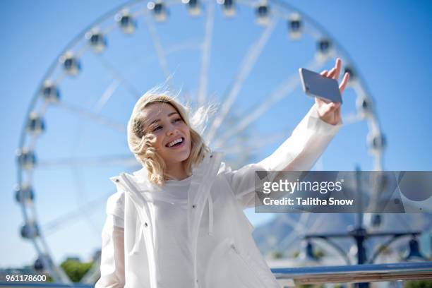 woman taking selfie in front of cape wheel, victoria and alfred waterfront, cape town, south africa - alfred weiss stock-fotos und bilder