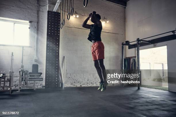 man in gym jumping in mid air - heshphoto foto e immagini stock