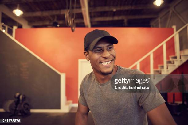 portrait of man in baseball cap looking away smiling - heshphoto stock-fotos und bilder