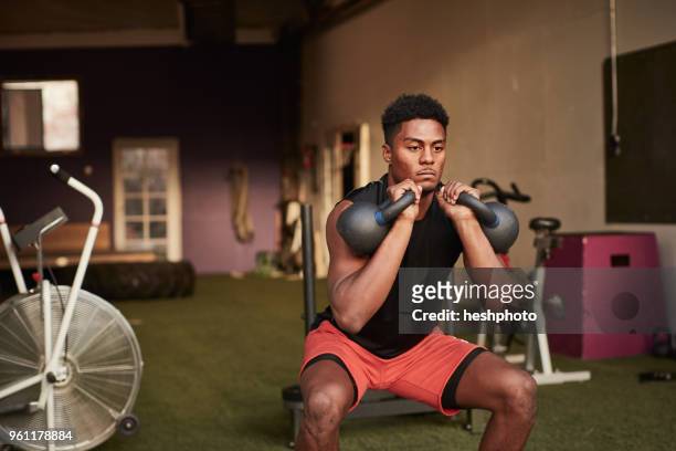 man in gym using kettle bells - heshphoto fotografías e imágenes de stock