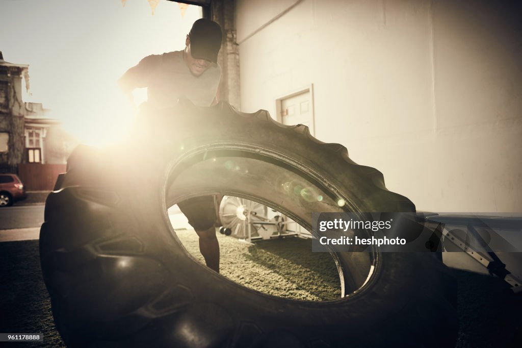 Man lifting large tire