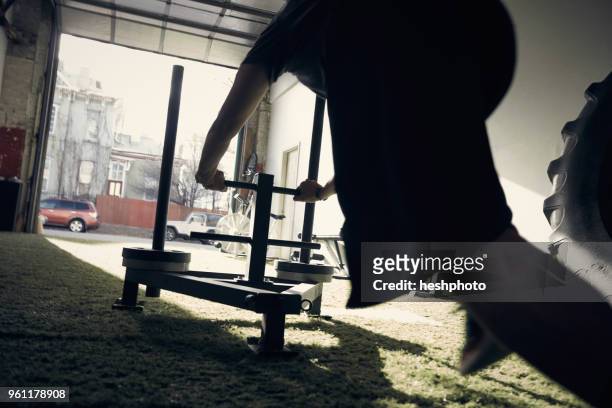 man in gym using exercise equipment - heshphoto foto e immagini stock