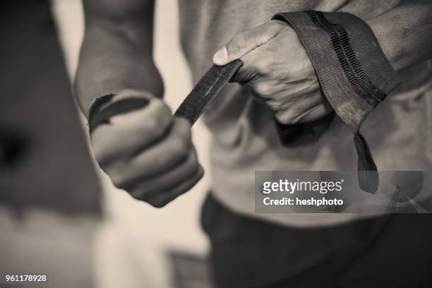 cropped view of man strapping hands with weightlifting straps - heshphoto fotografías e imágenes de stock