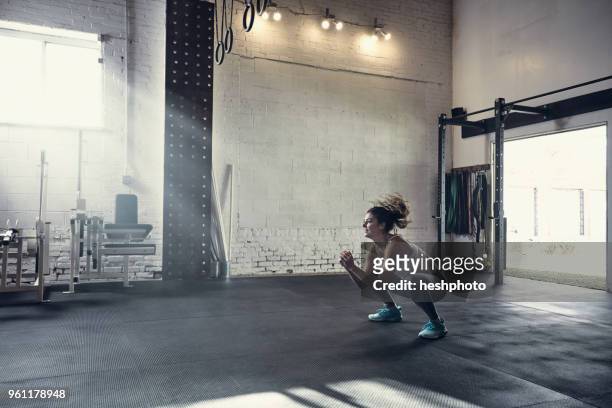 woman in gym doing squats - heshphoto stock-fotos und bilder