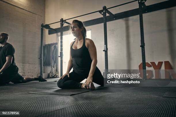 woman in yoga position in gym - heshphoto stockfoto's en -beelden
