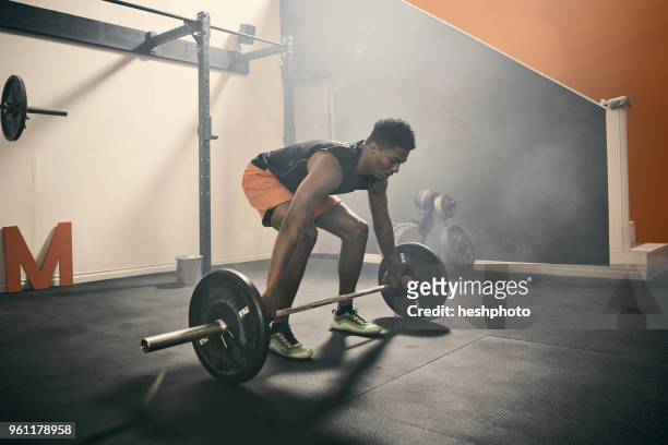 man in gym weightlifting using barbell - heshphoto stockfoto's en -beelden