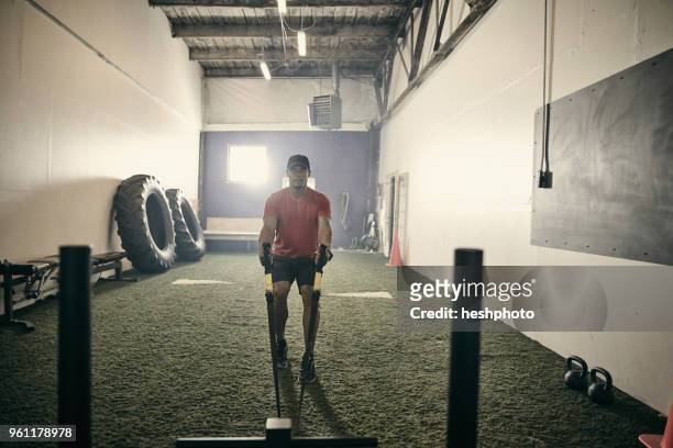 man in gym using exercise equipment - heshphoto stock-fotos und bilder