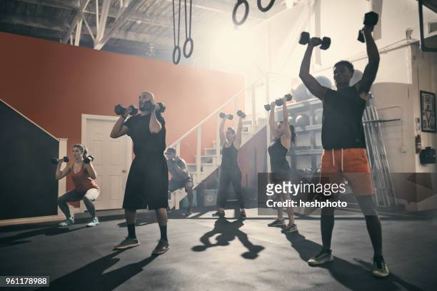 man using dumbbells in gym - heshphoto stock pictures, royalty-free photos & images