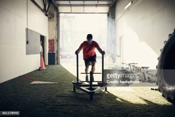 man in gym using exercise equipment - heshphoto stockfoto's en -beelden