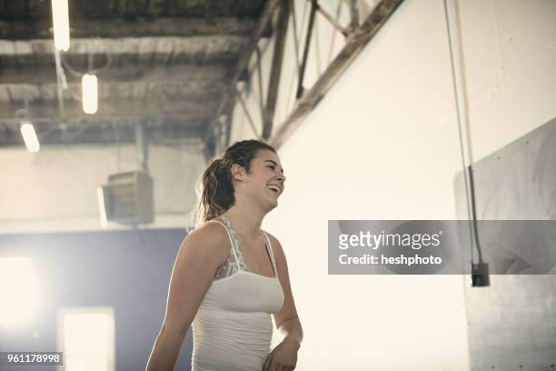 portrait of woman in gym looking away smiling - heshphoto stockfoto's en -beelden