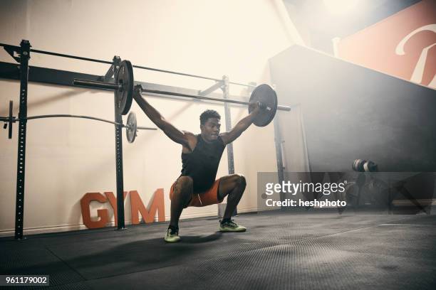 man in gym weightlifting using barbell - heshphoto stock-fotos und bilder