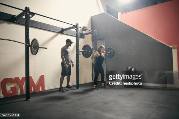 woman in gym weightlifting using barbell - heshphoto stock-fotos und bilder