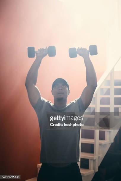 man using dumbbells in gym - heshphoto fotografías e imágenes de stock