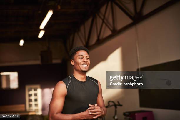 portrait of man in gym looking away smiling - heshphoto stock-fotos und bilder