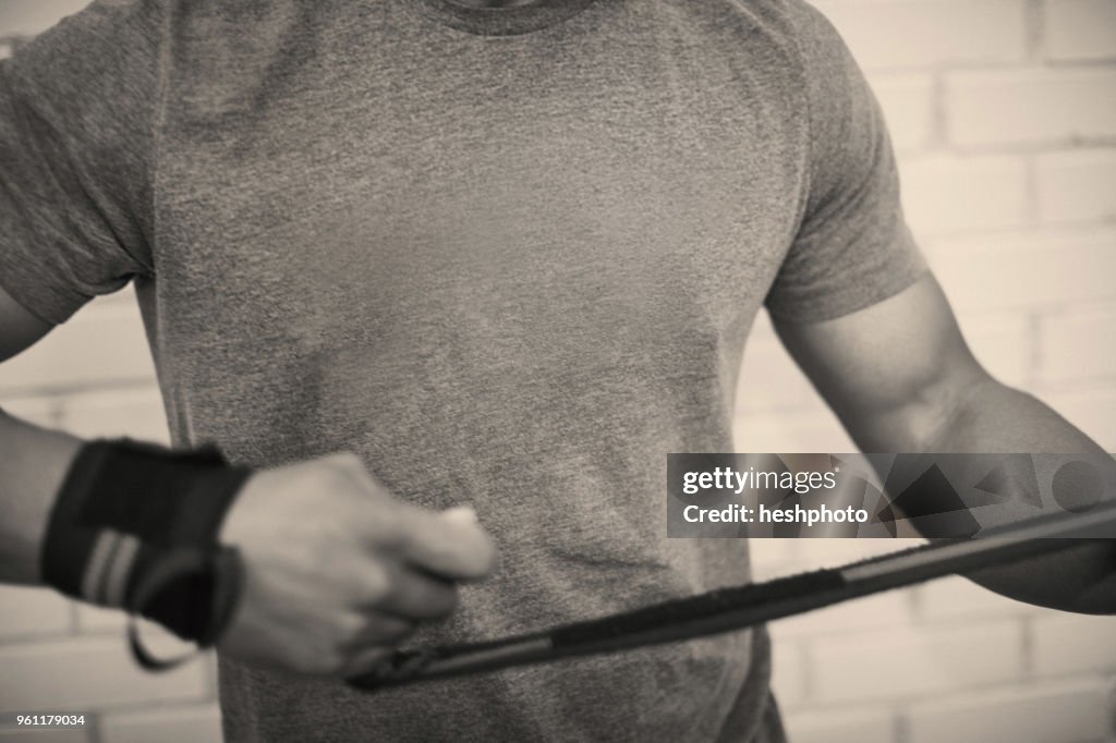 Cropped view of man strapping hands with weightlifting straps