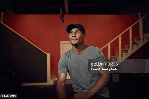 portrait of man in baseball cap looking away - heshphoto stockfoto's en -beelden