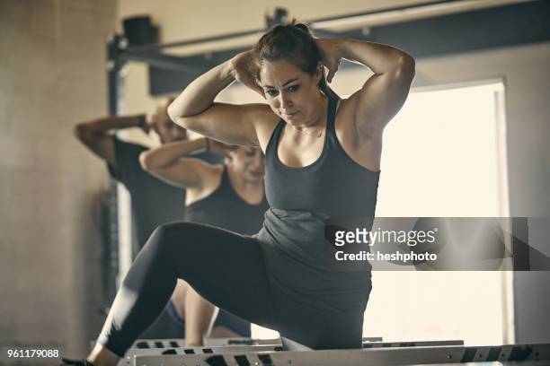 woman exercising in gym - heshphoto fotografías e imágenes de stock