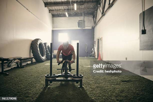 man in gym using exercise equipment - heshphoto stock-fotos und bilder
