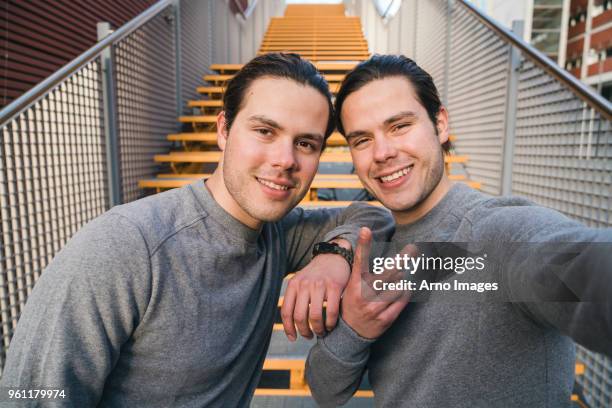 young adult male twins training together, stairway self portrait - twin stock pictures, royalty-free photos & images