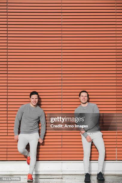 young adult male twins taking a training break, urban portrait - identical twin stock pictures, royalty-free photos & images