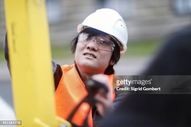 young construction worker wearing hard hat - sigrid gombert fotografías e imágenes de stock